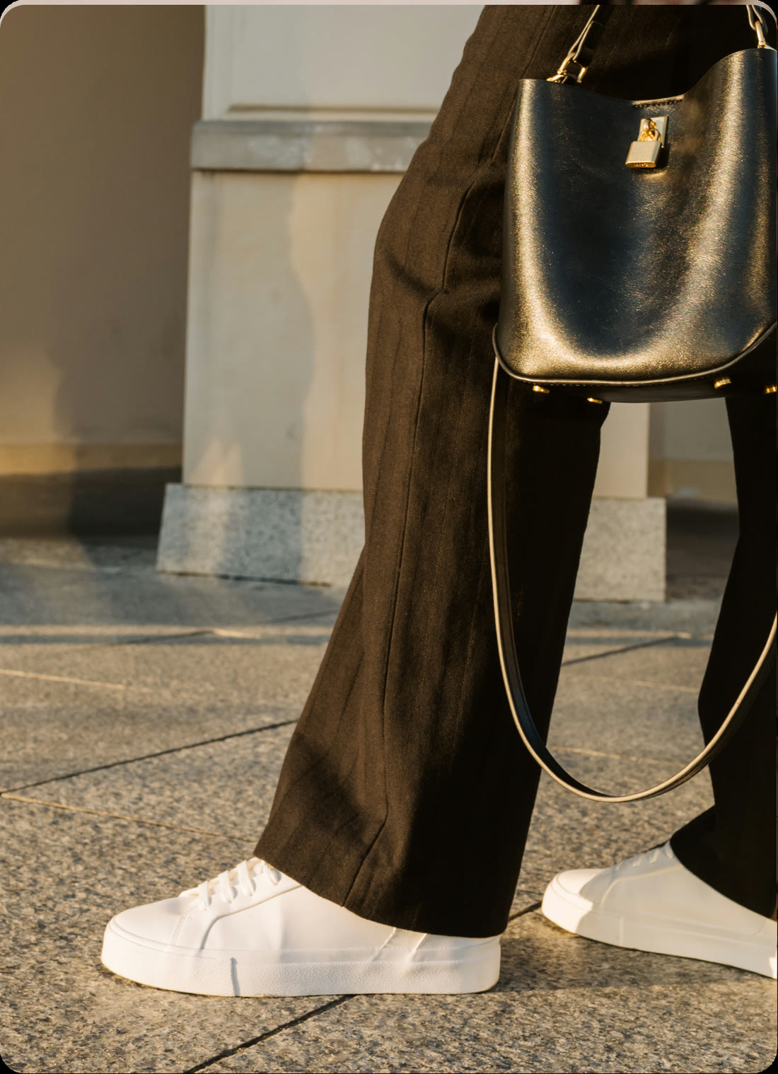 White trainers and a black leather bag