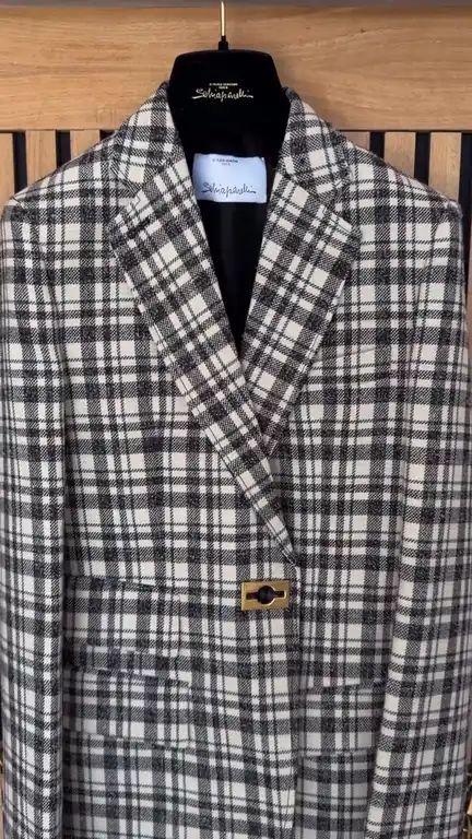 A Schiaparelli checked jacket being dry cleaned and its gold buttons sewn back on, in the London Laundry Club workroom